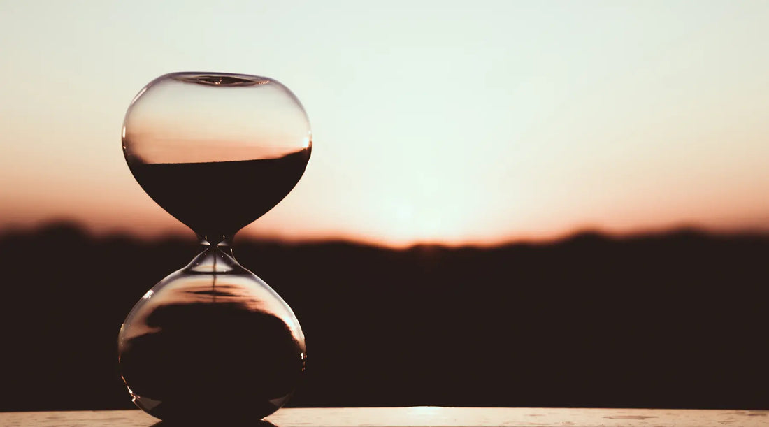 Hourglass with a sunset in the background depicting how long do supplements take to work 